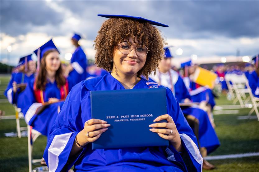 Students in blue robes graduate